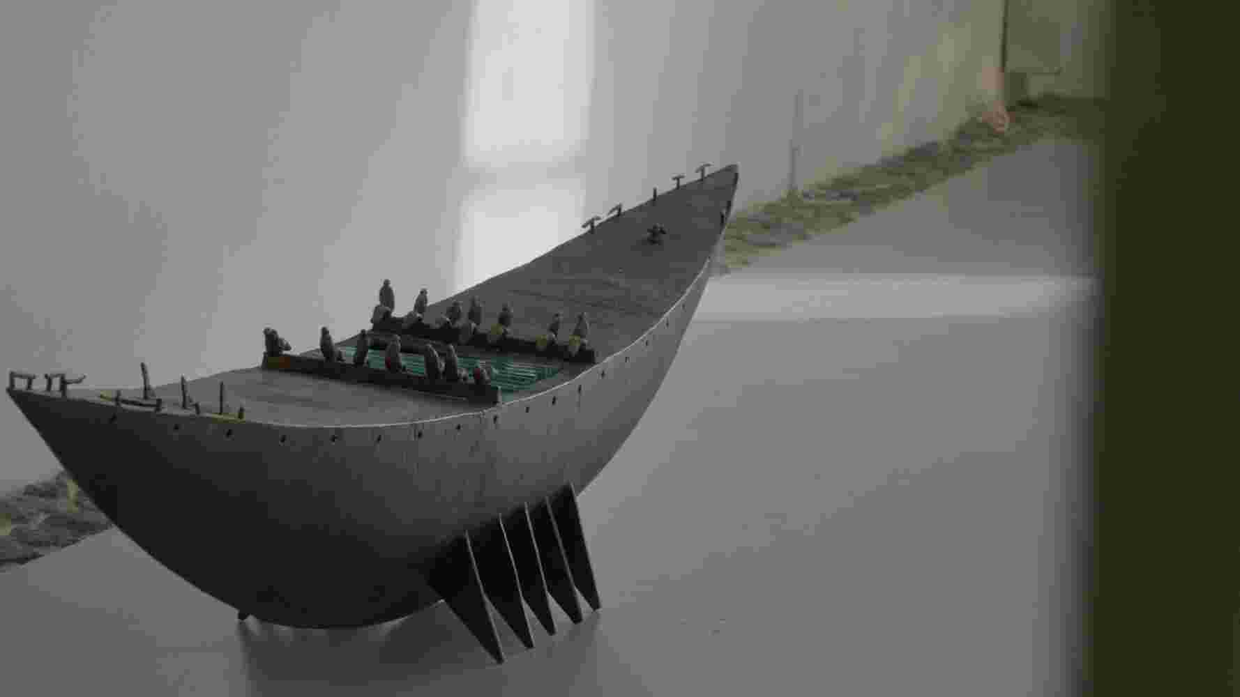 Ceremonial Sculpture of a boat with people made of cast bronze and glass