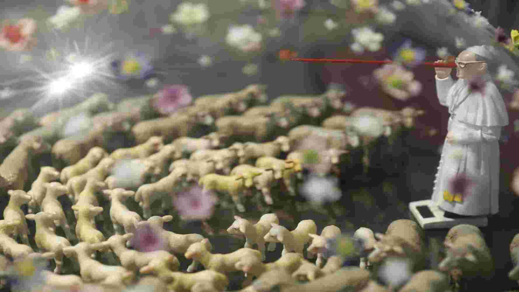 The Utopia Maker Contemporary sculpture of a pope with a Pinocchio nose and sheep and colorful flowers made of plexiglass, bronze and found objects