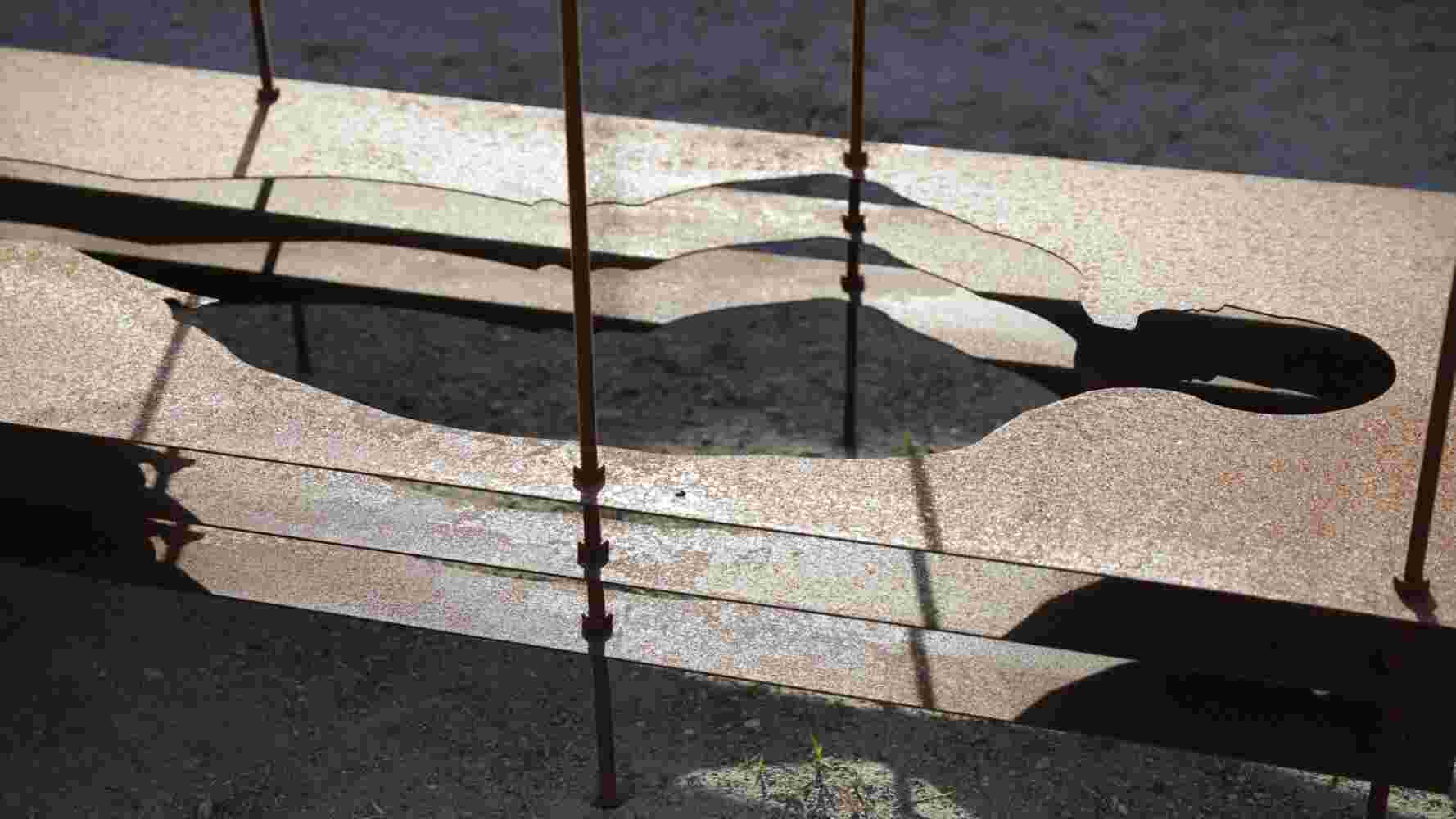 Homo Erectus Sculpture made of multiple layers of rusted steel with the shape of a human cut in the middle