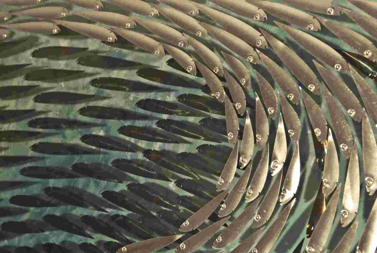 Three-dimensional wall sculpture, school of fish theme, with layers of plexiglass, aluminum frame and swirling aluminum and copper fish.