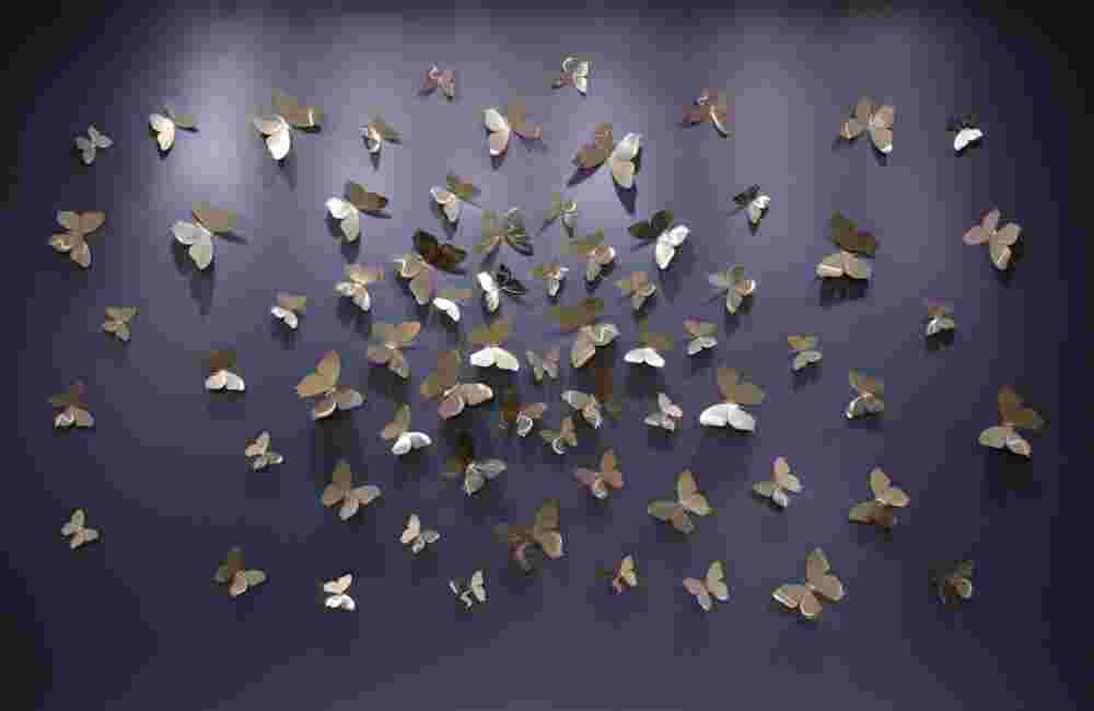Wall installation made of 68 pieces of different size stainless-steel butterflies.