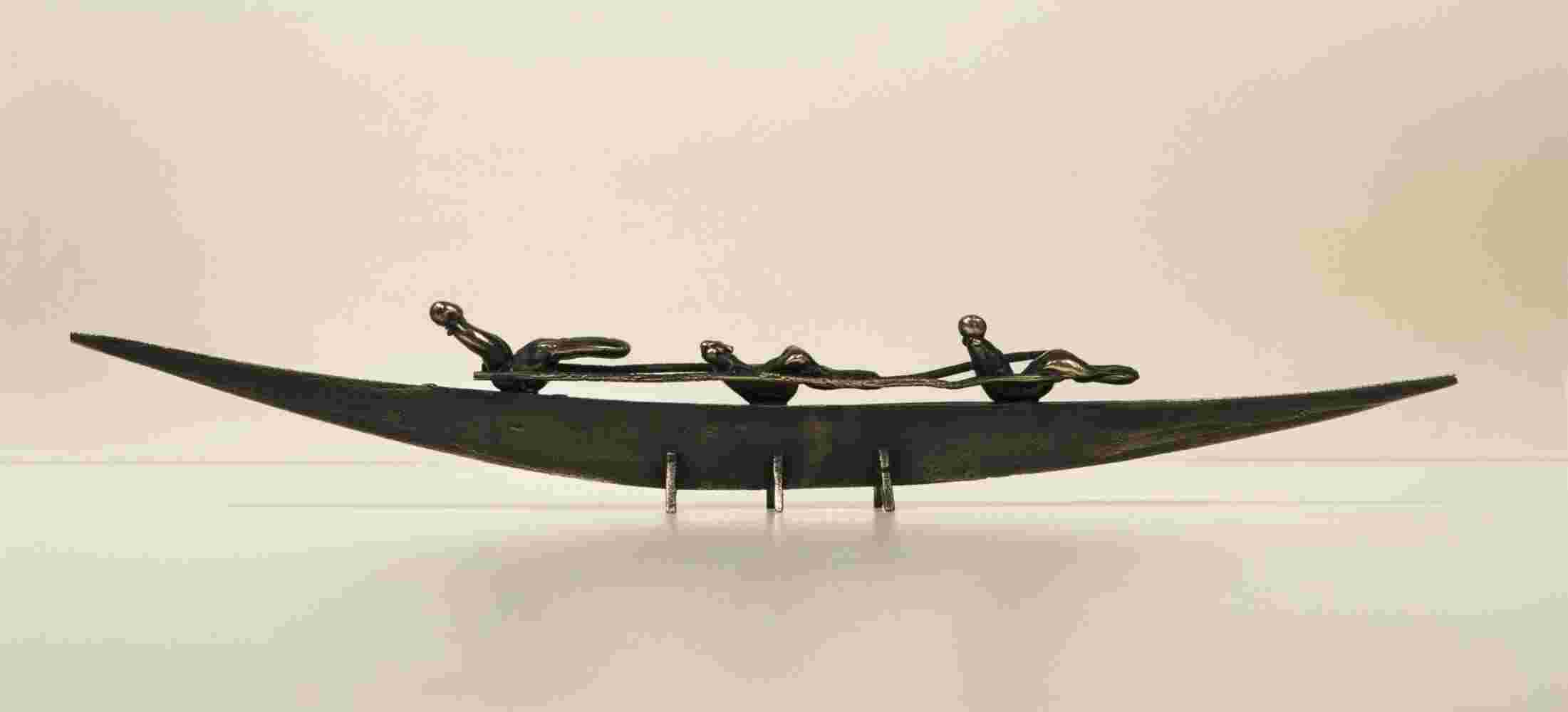 Small boat sculpture made of cast bronze.