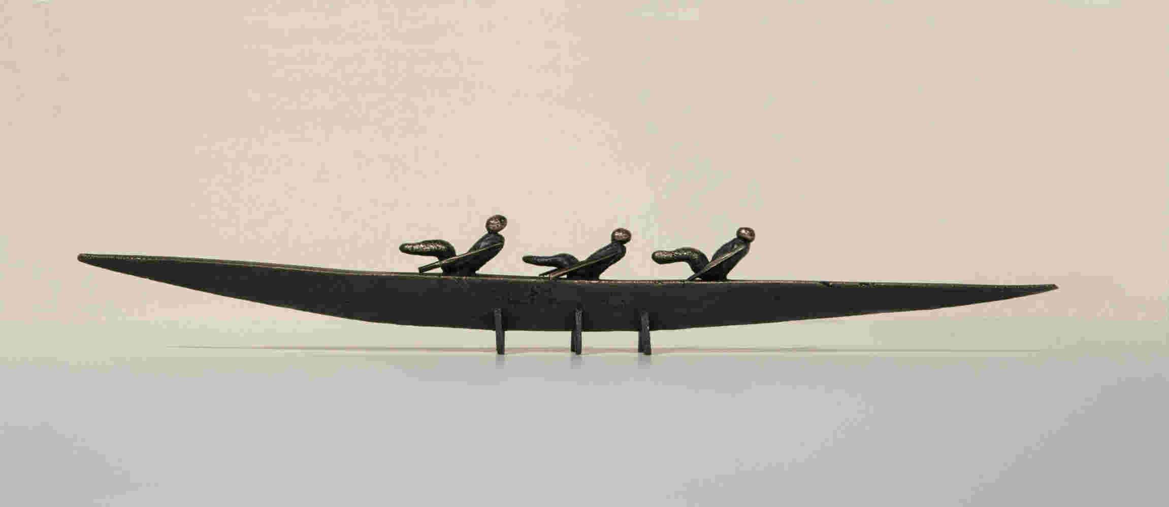 Small boat sculpture made of cast bronze.