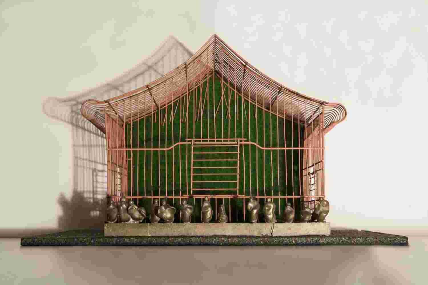 Mixed media wall sculpture of a cage with little people made of bronze