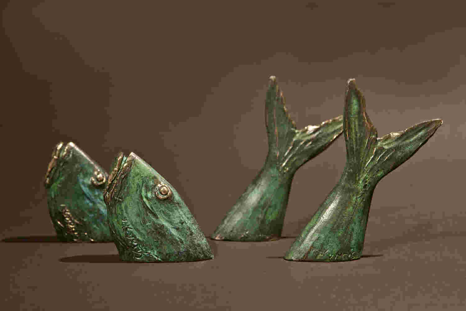 Fish small green bronze sculpture going in and out of the water