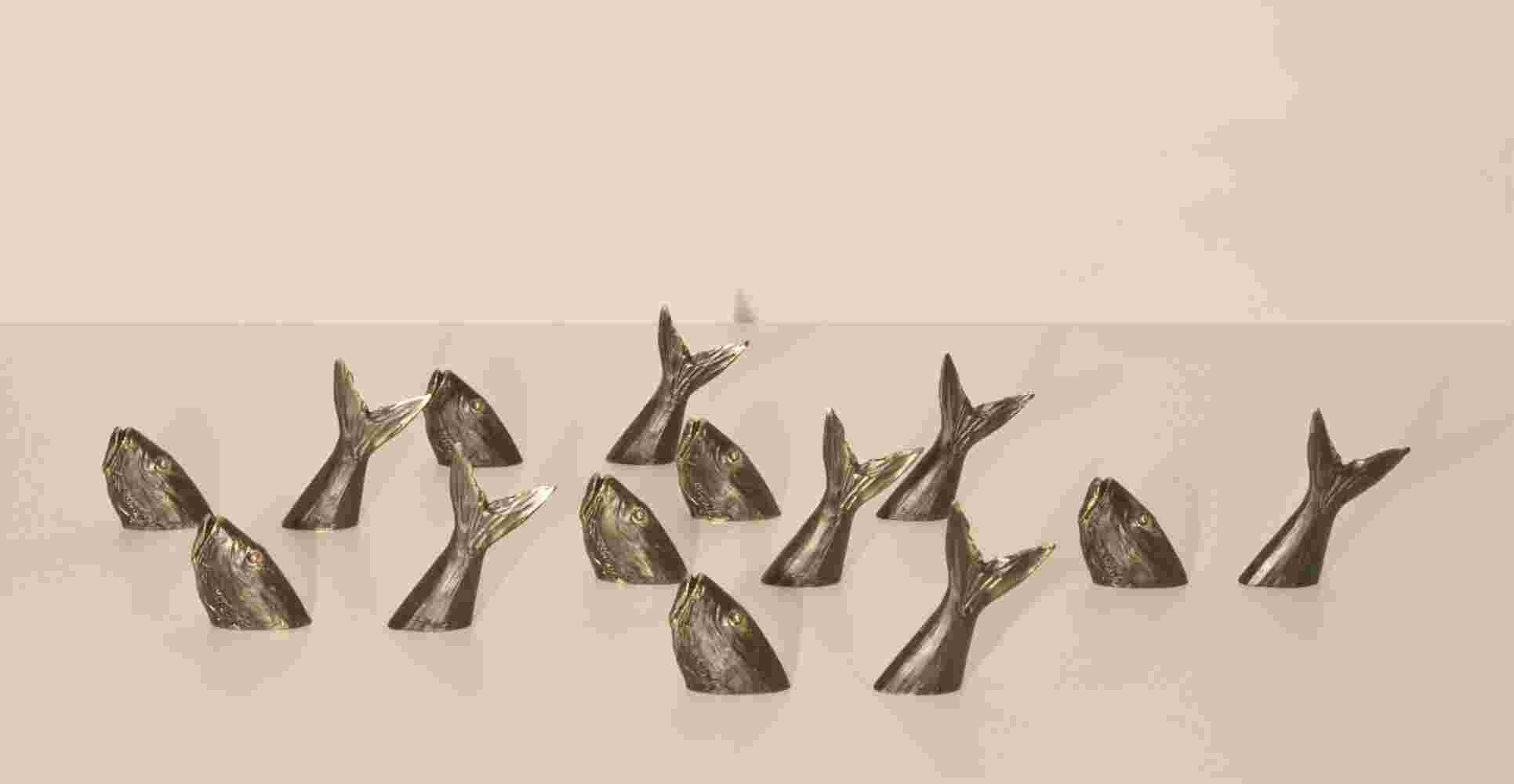 Composition of fish small bronze sculpture going in and out of the water