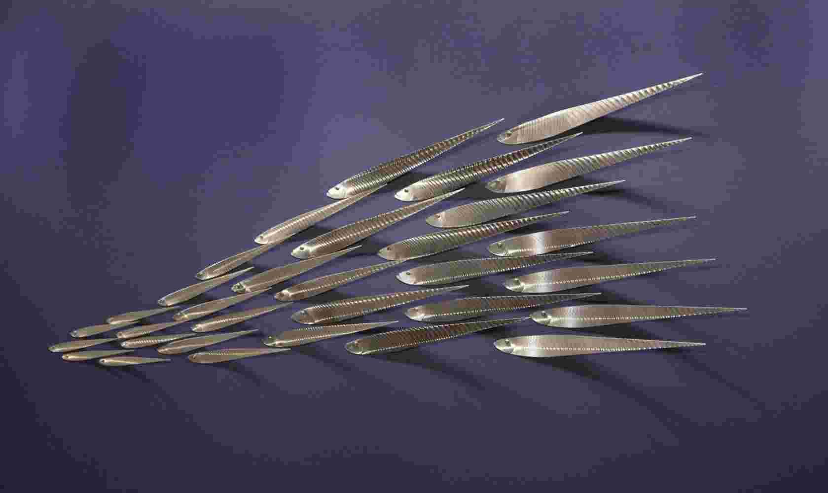 Wall installation of flowing stainless steel school of fish