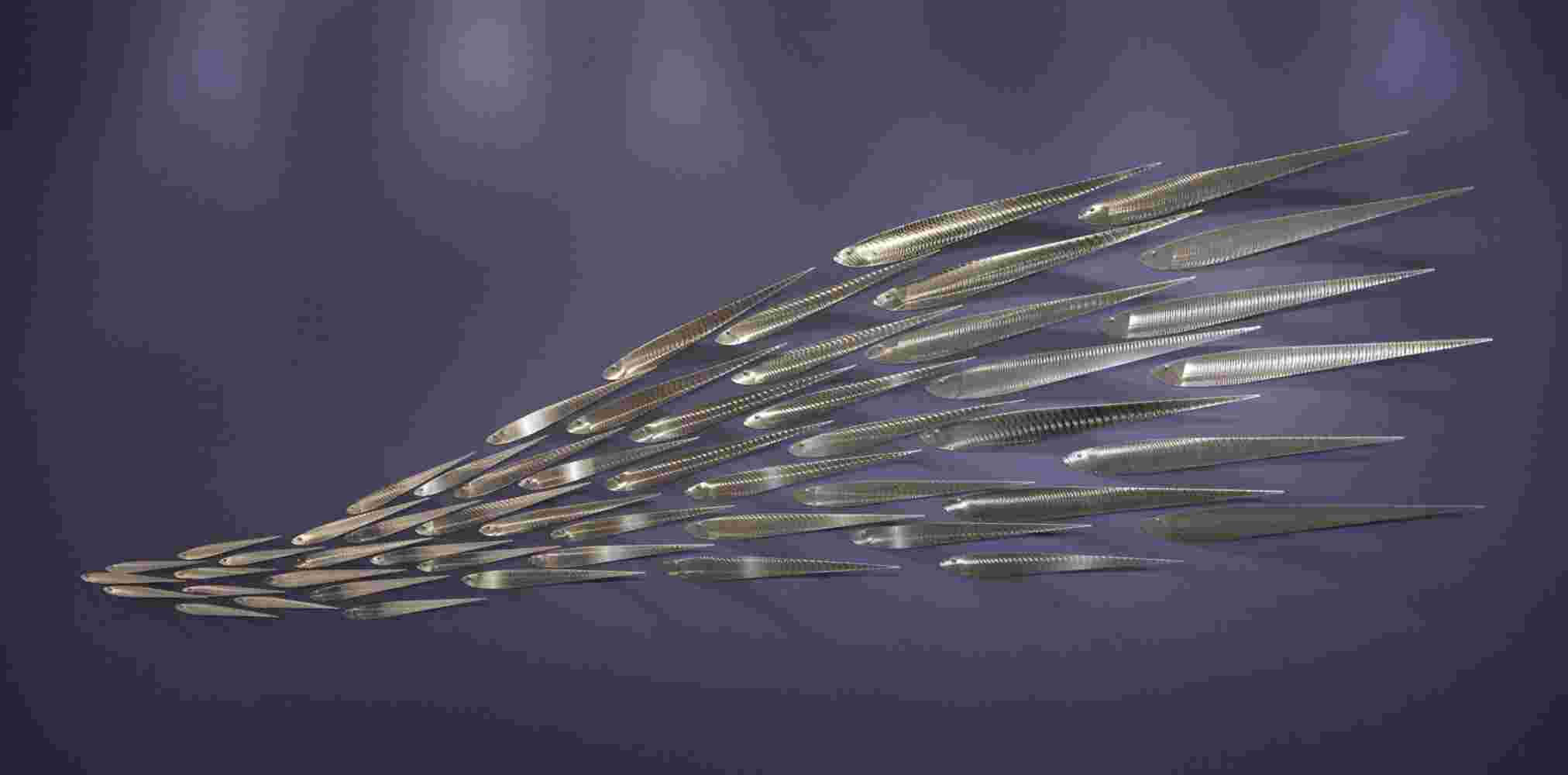 Wall installation of a flowing stainless steel school of fish