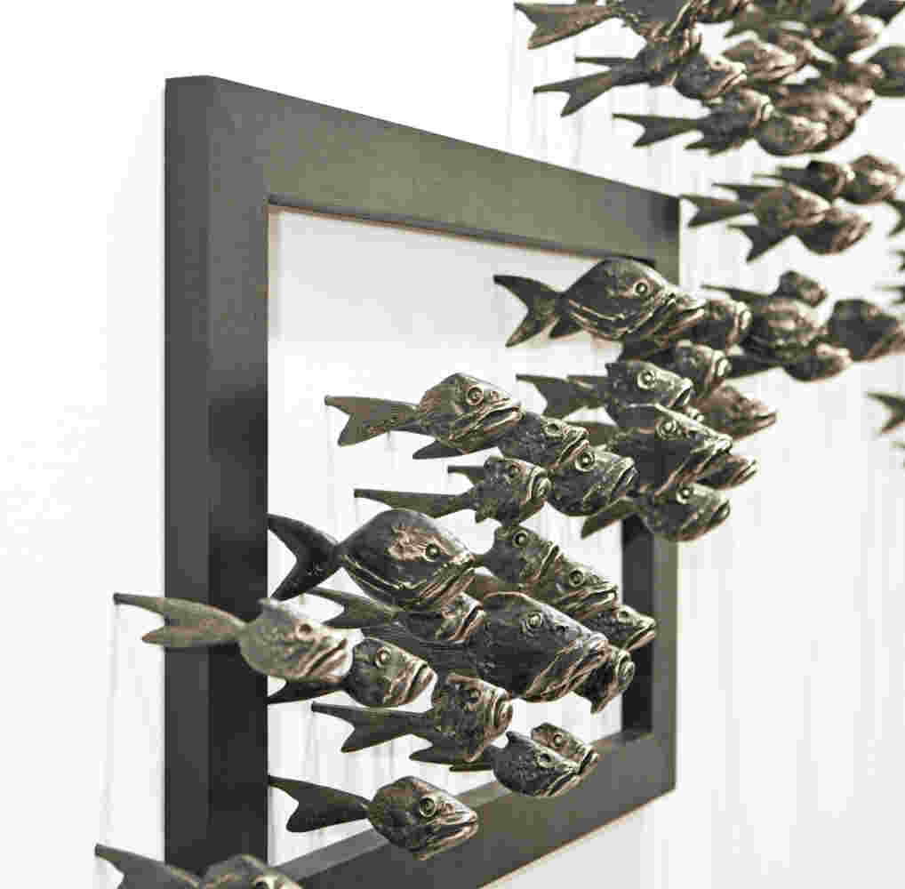 Wall installation of an explosion of fish made of cast bronze and a wooden frame.