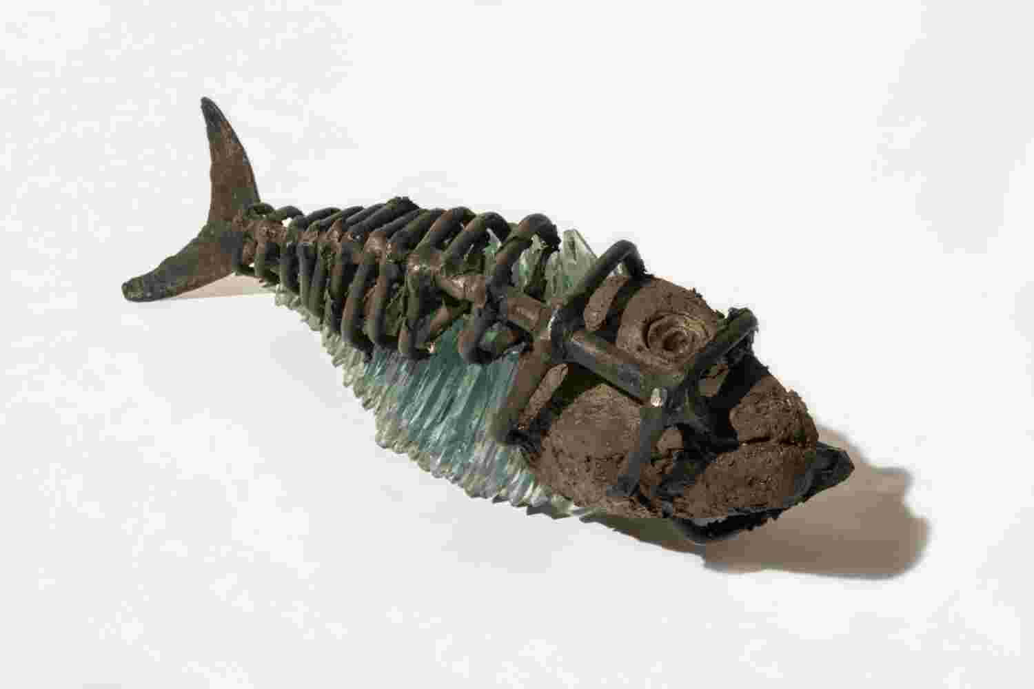 Glass and bronze fish sculpture inside a bronze cage.