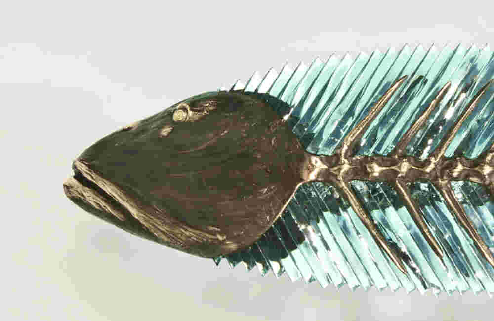 Hand cut glass and bronze wall sculpture of a fish.