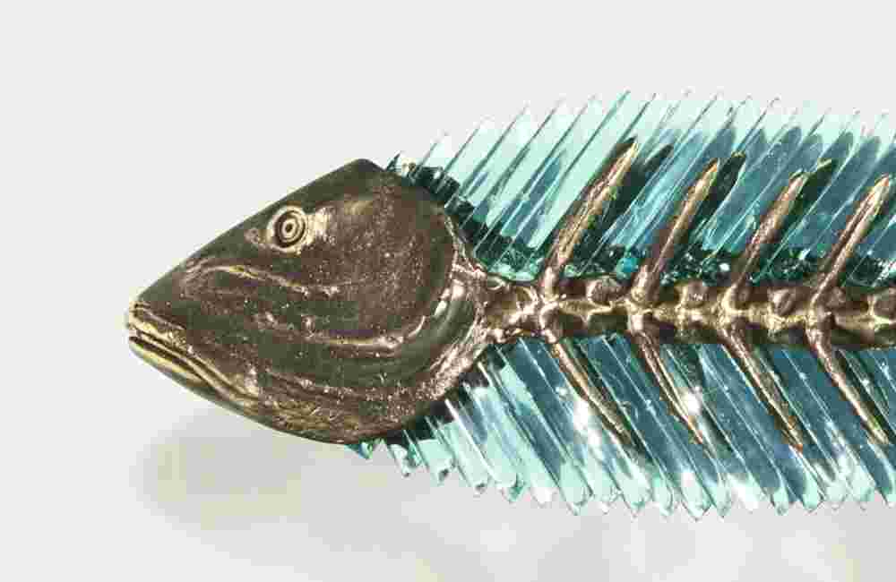 Hand cut glass and bronze wall sculpture of a fish.