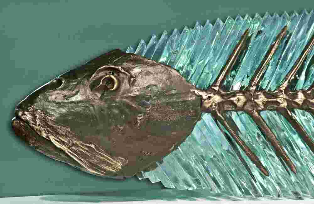 Hand cut glass and bronze sculpture of a fish.