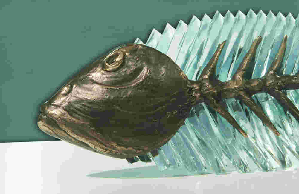 Hand cut glass and bronze sculpture of a fish.