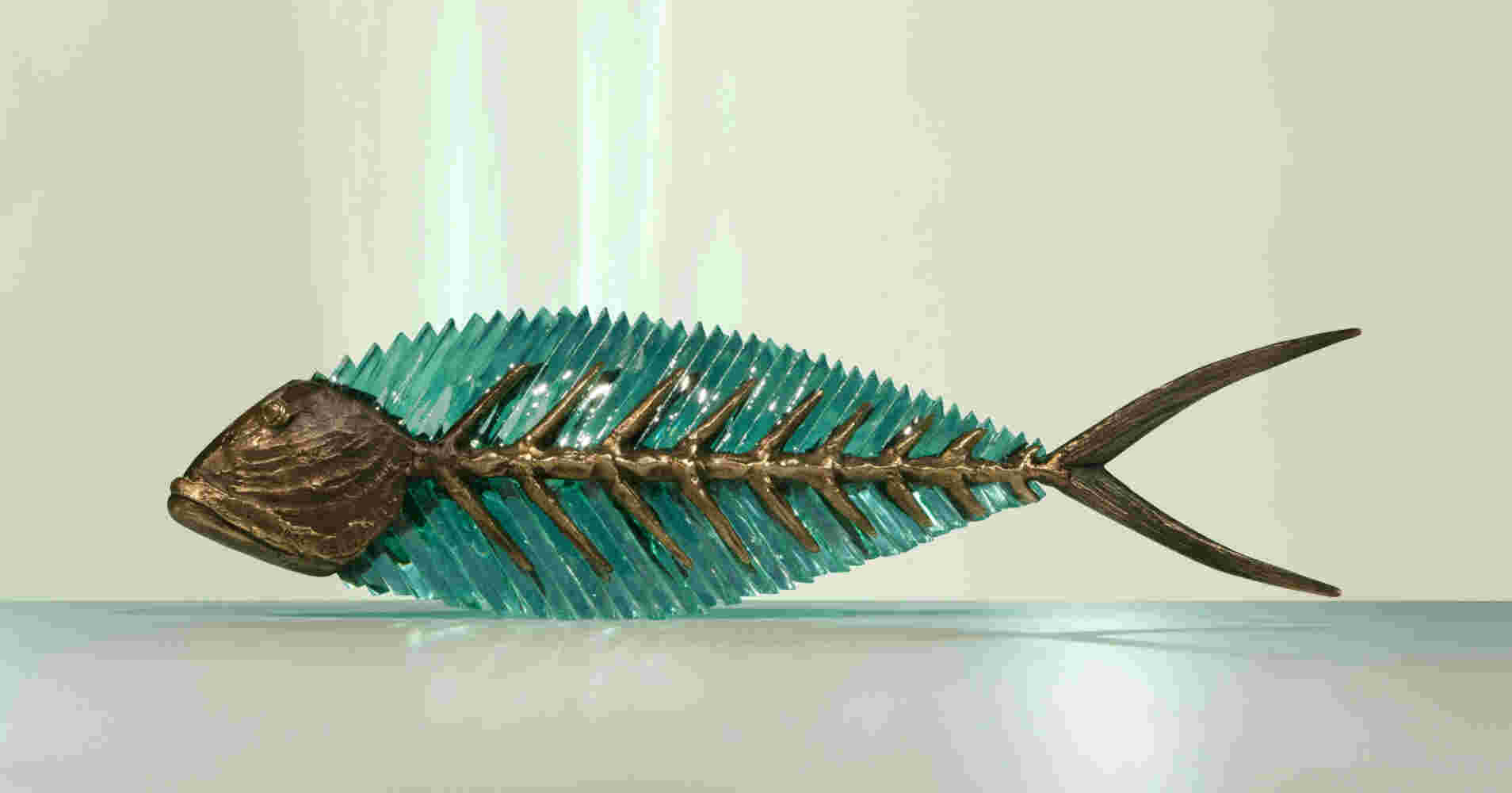 Hand cut glass and bronze sculpture of a fish.