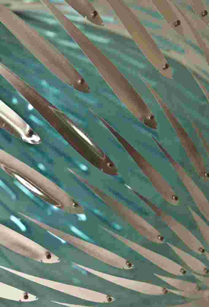 Acrylic hemisphere with metallic fish create a swirling effect that resembles underwater shoals