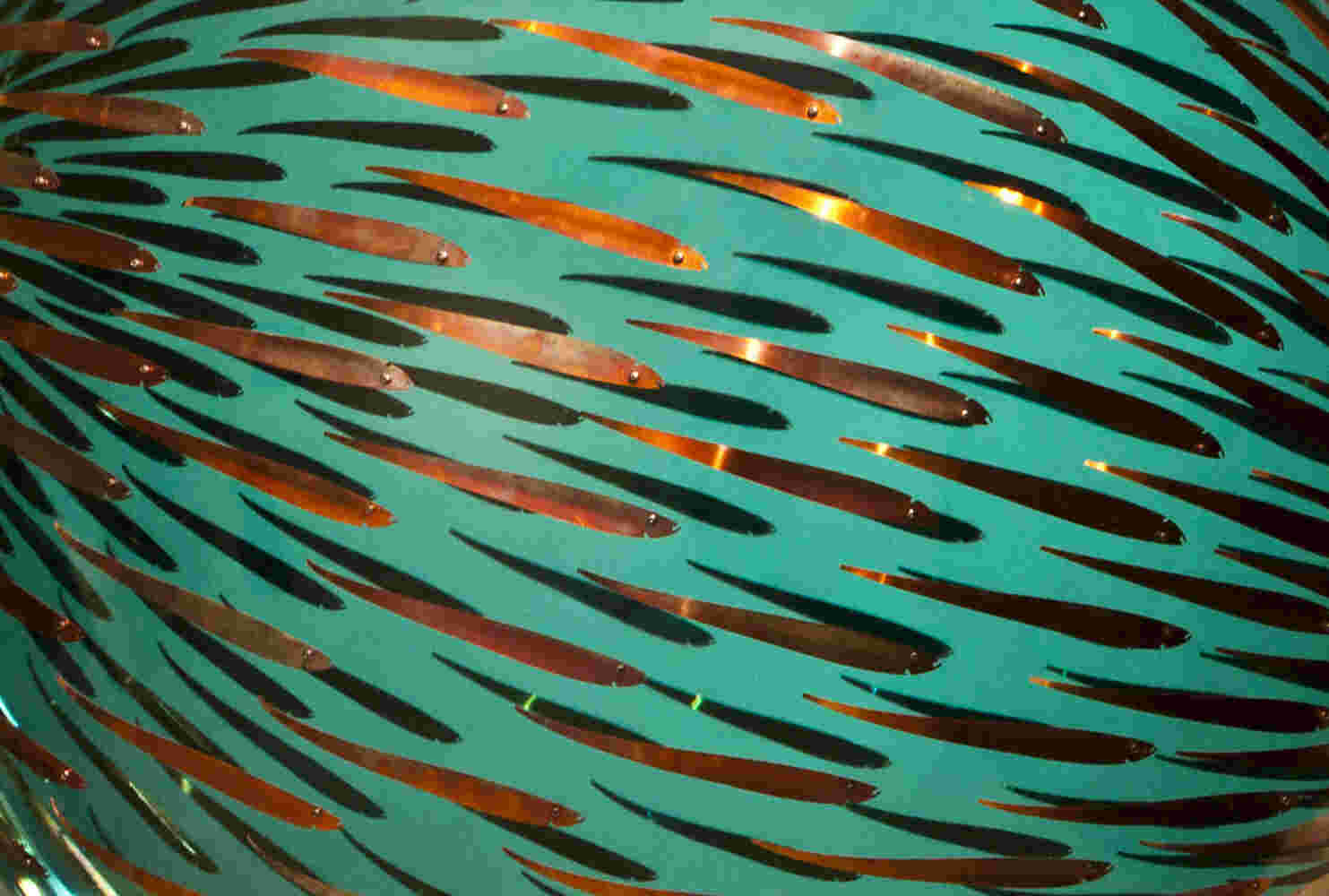 Acrylic hemisphere with metallic fish create a swirling effect that resembles underwater shoals.