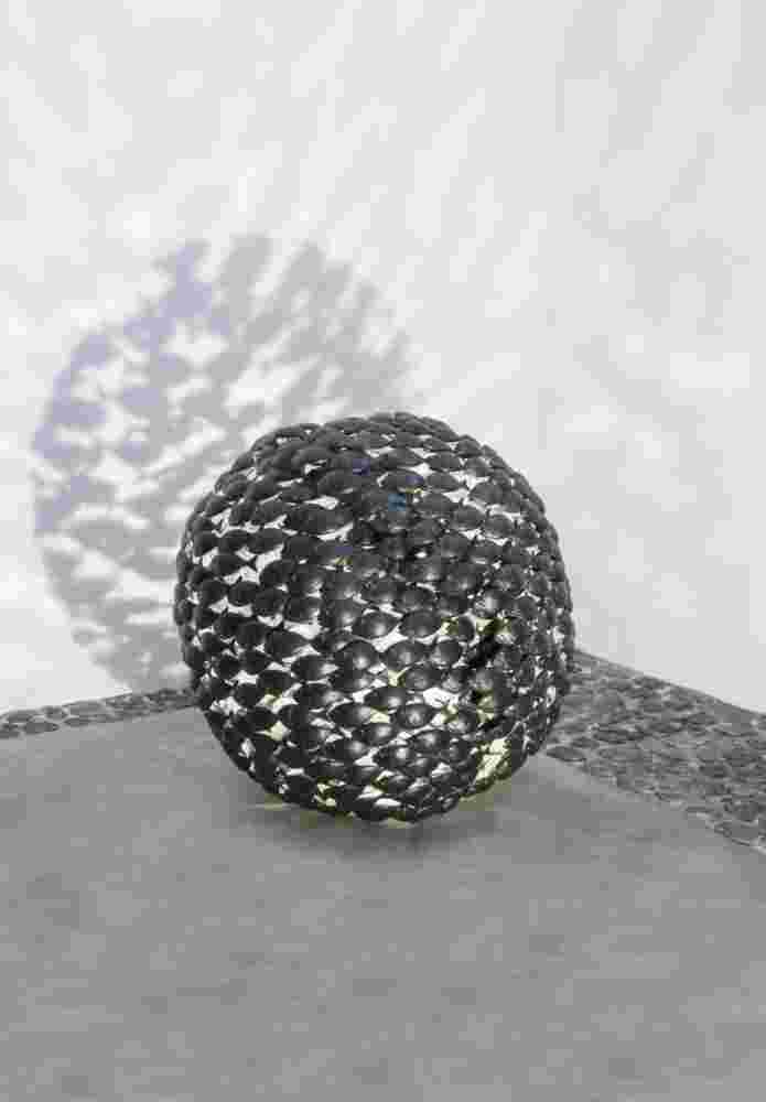 Sphere of a school of fish made of cast bronze with a green patina inside.