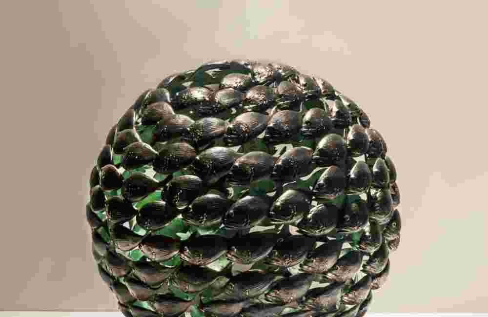 Bronze fish shoal ball with a green interior made of cast bronze
