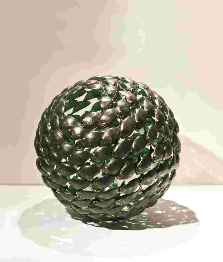 Bronze fish shoal ball with a green interior made of cast bronze
