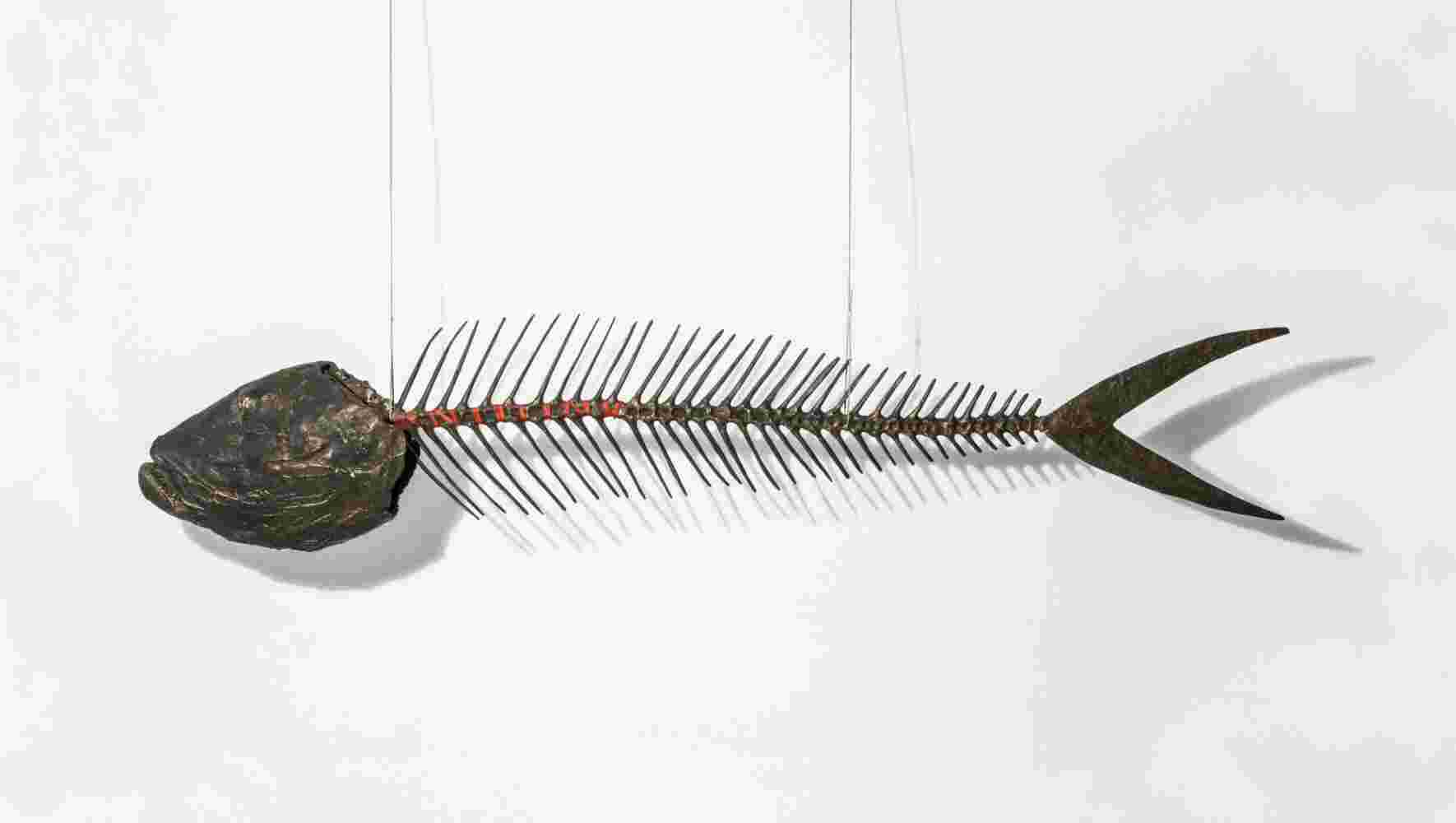 Hanging large scale sculpture of a fish bone made of cast bronze and red string.