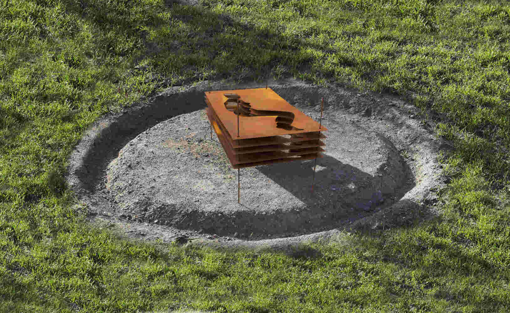 Sculpture made of multiple layers of rusted steel with the shape of a human cut in the middle