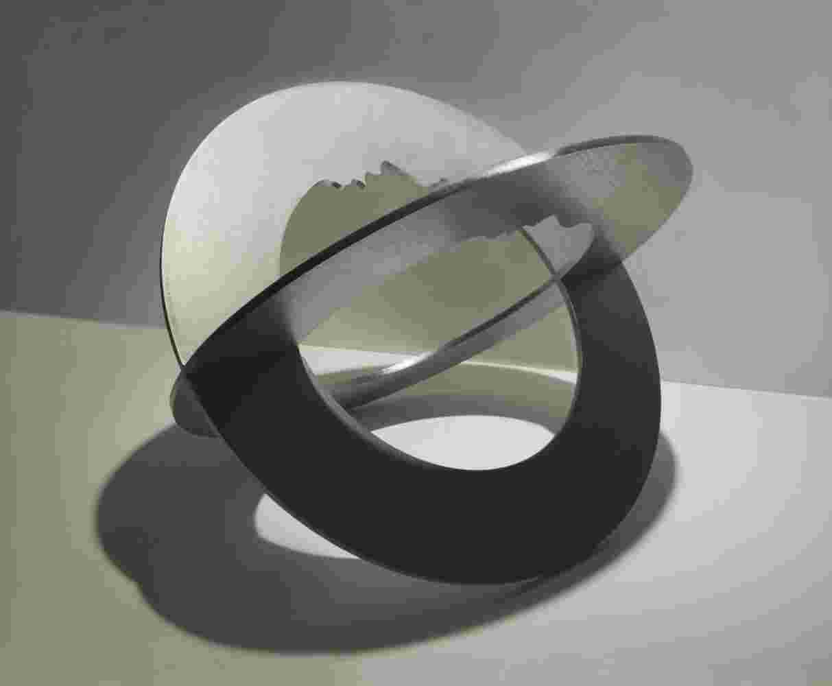 Spherical staineless steel sculpture with a cut out of a head