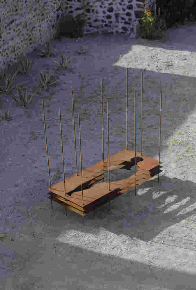 Sculpture made of multiple layers of rusted steel with the shape of a human cut in the middle