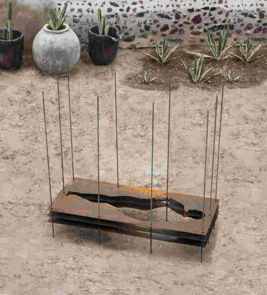 Sculpture made of multiple layers of rusted steel with the shape of a human cut in the middle