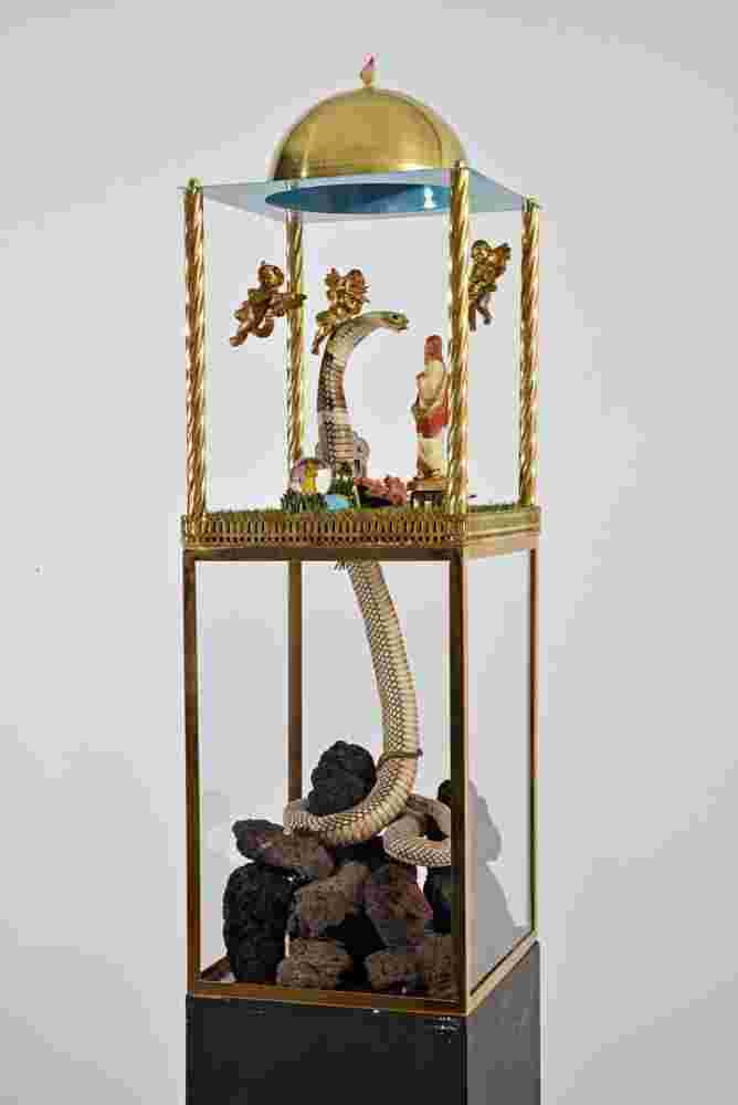 Mixed media sculpture containing a snake, angels and the figure of Christ inside a domed structure with a sky