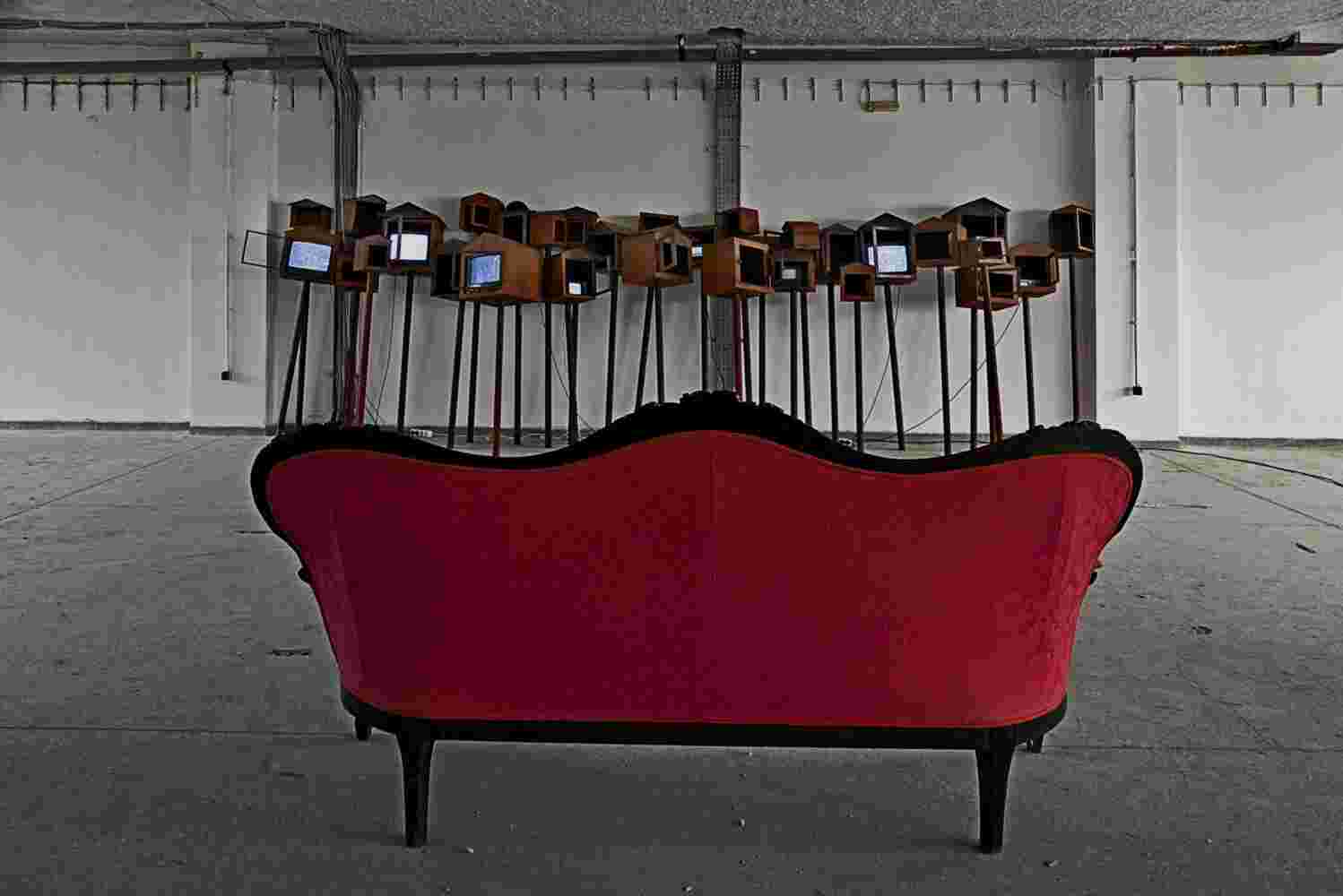 Large art installation of 29 shrines made of rusted steel and a sofa