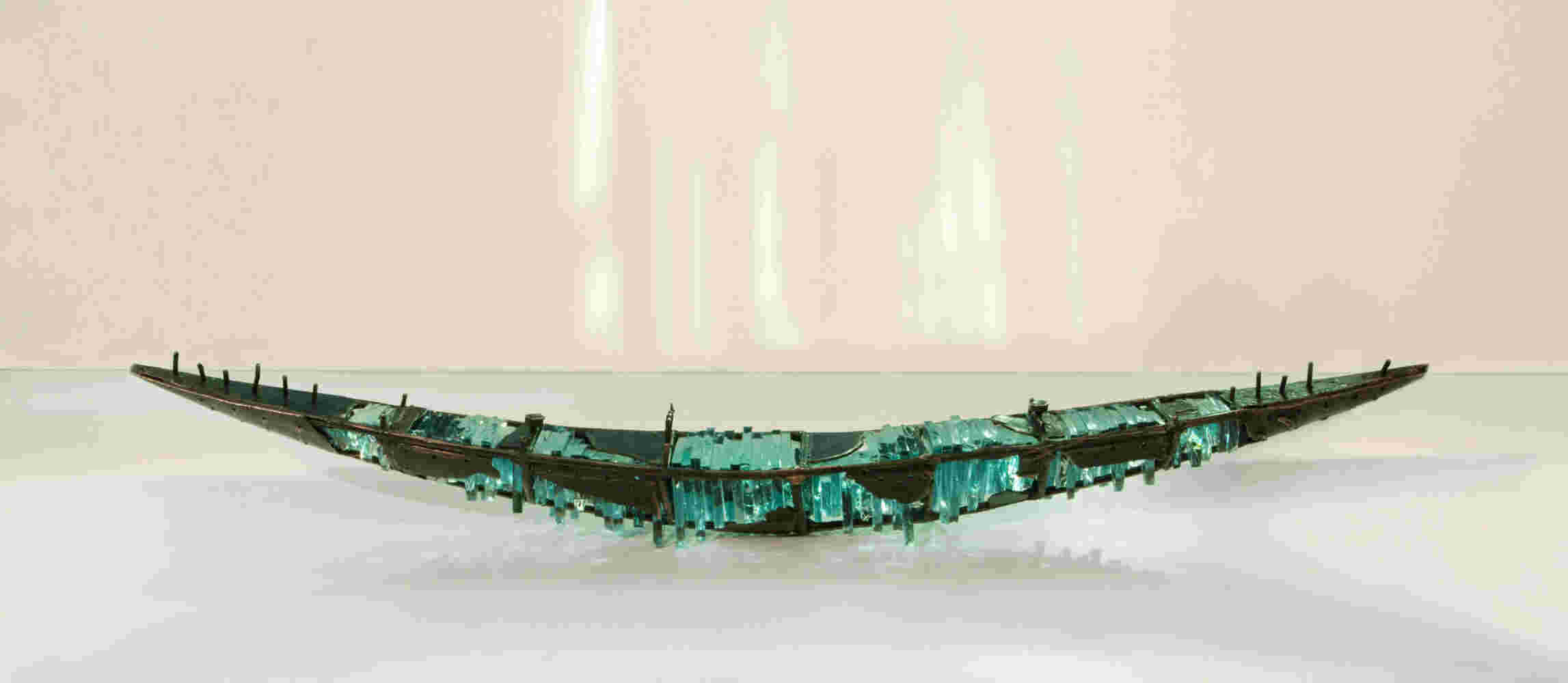 Shipwreck boat sculpture made of hand cut glass and bronze.