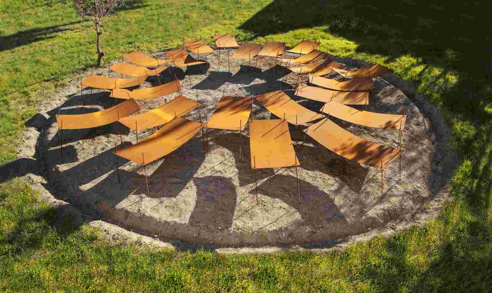 Rusted steel exterior art installation resembling a group of beds gathered together