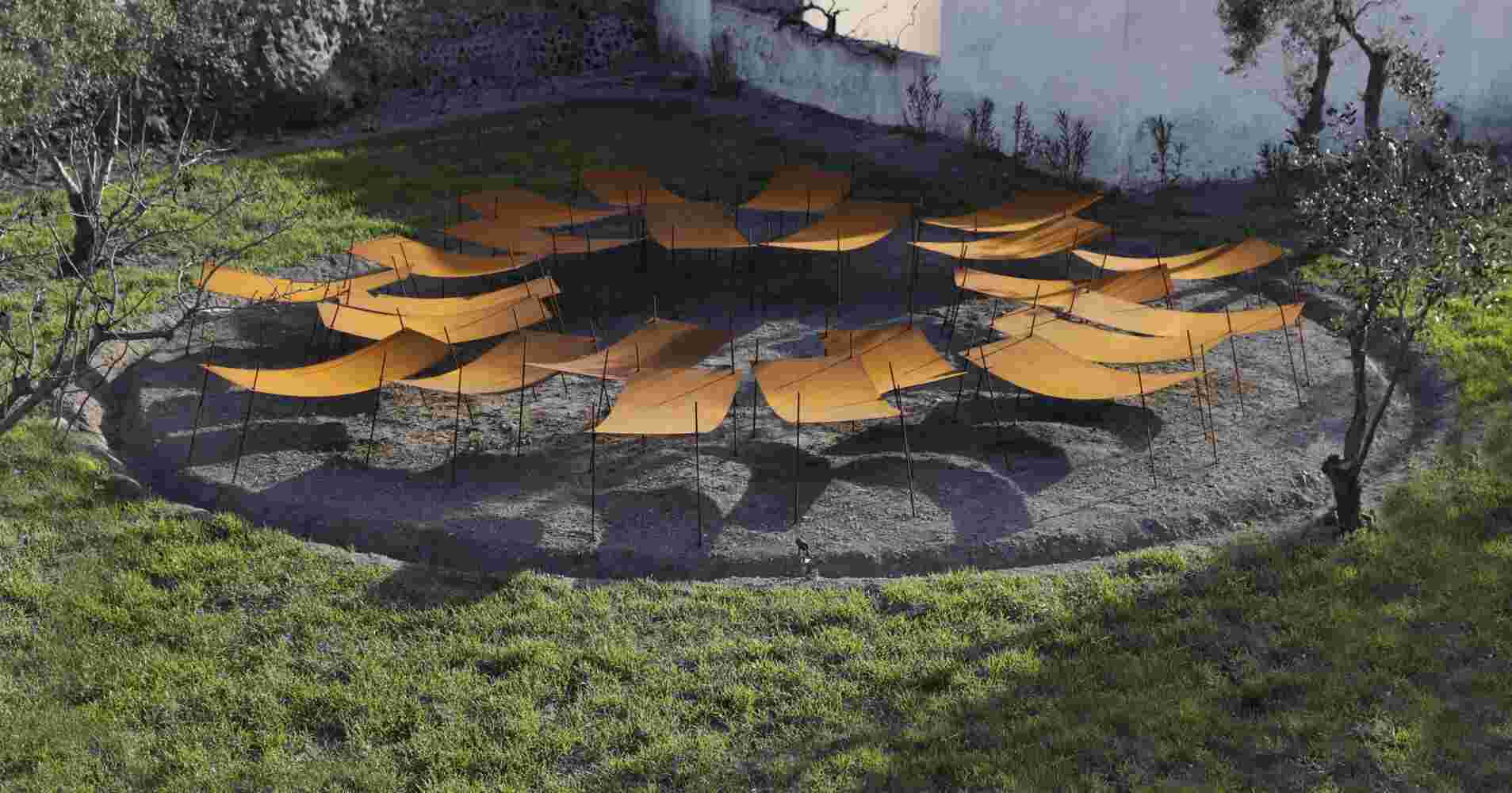 Rusted steel exterior art installation resembling a group of beds gathered together