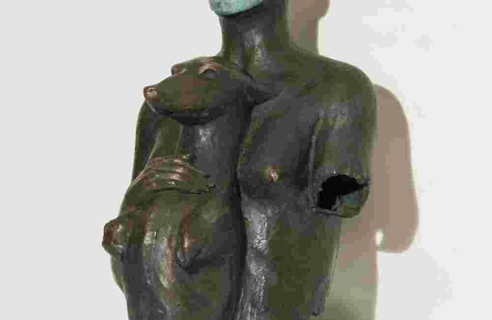 Bronze sculpture of a woman holding a dog