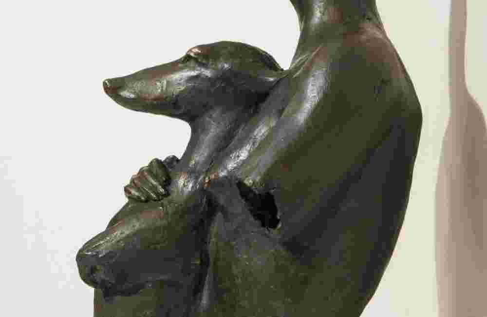 Bronze sculpture of a woman holding a dog