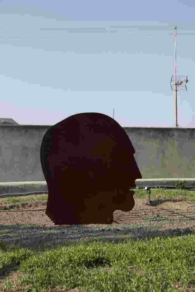 Multiple layers of rusted steel sheets face outdoors sculpture