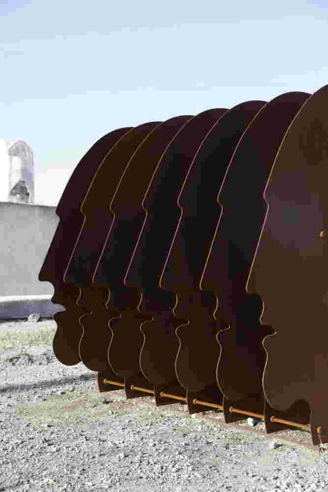 Multiple layers of rusted steel sheets face outdoors sculpture