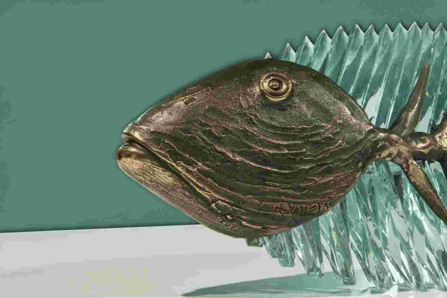 Hand cut glass and bronze sculpture of a fish.