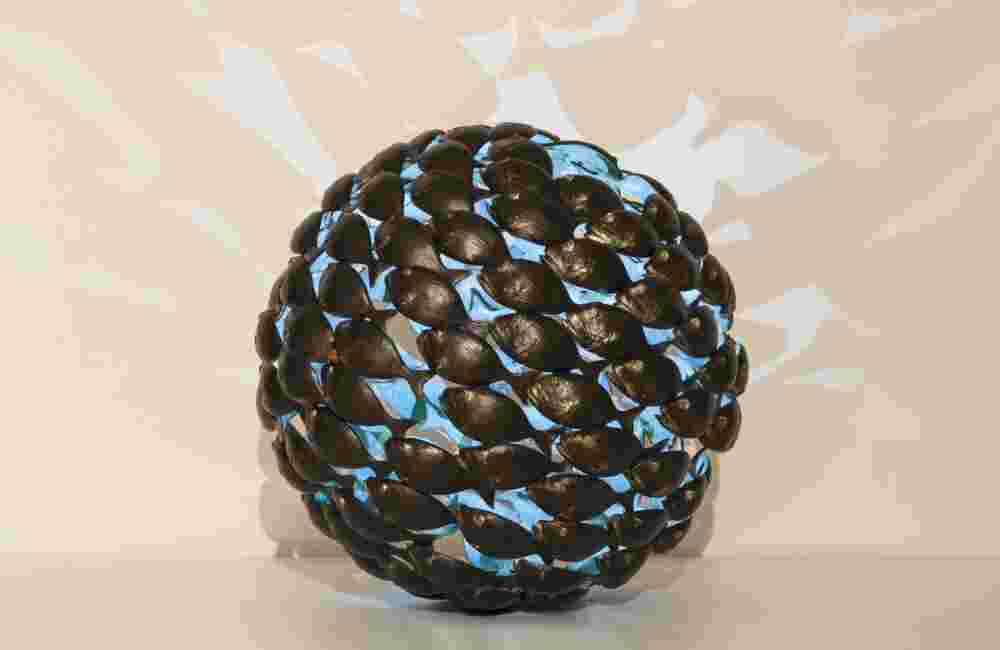 Sphere of a school of fish made of cast bronze with a green patina inside.