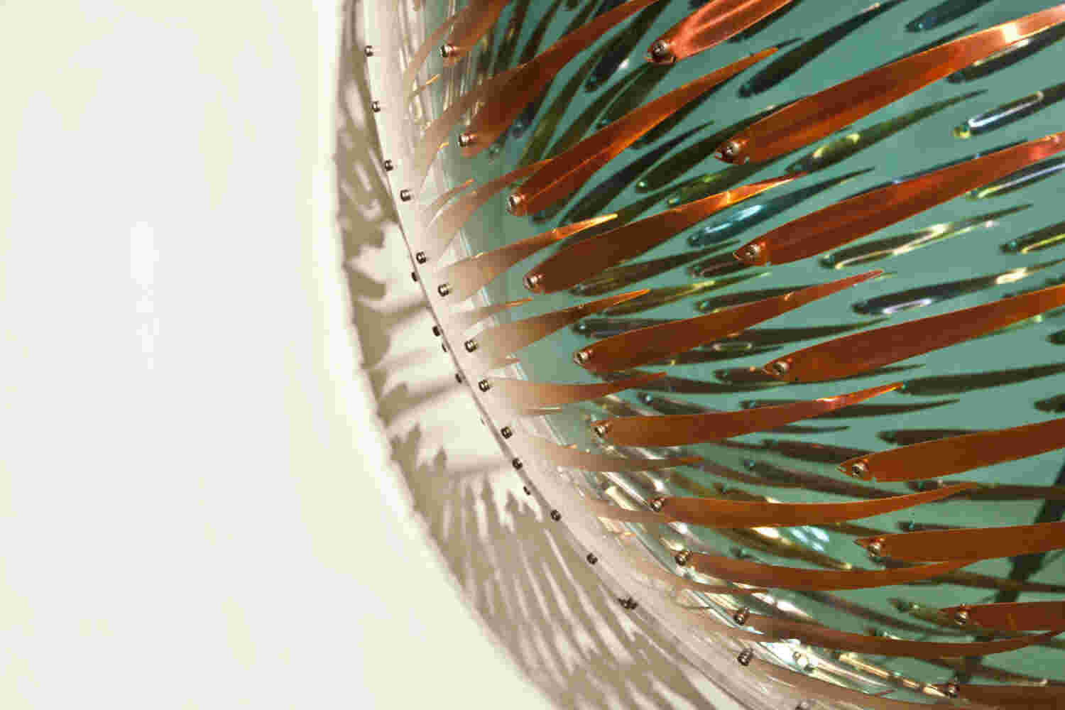 Acrylic hemisphere with metallic fish create a swirling effect that resembles underwater shoals.