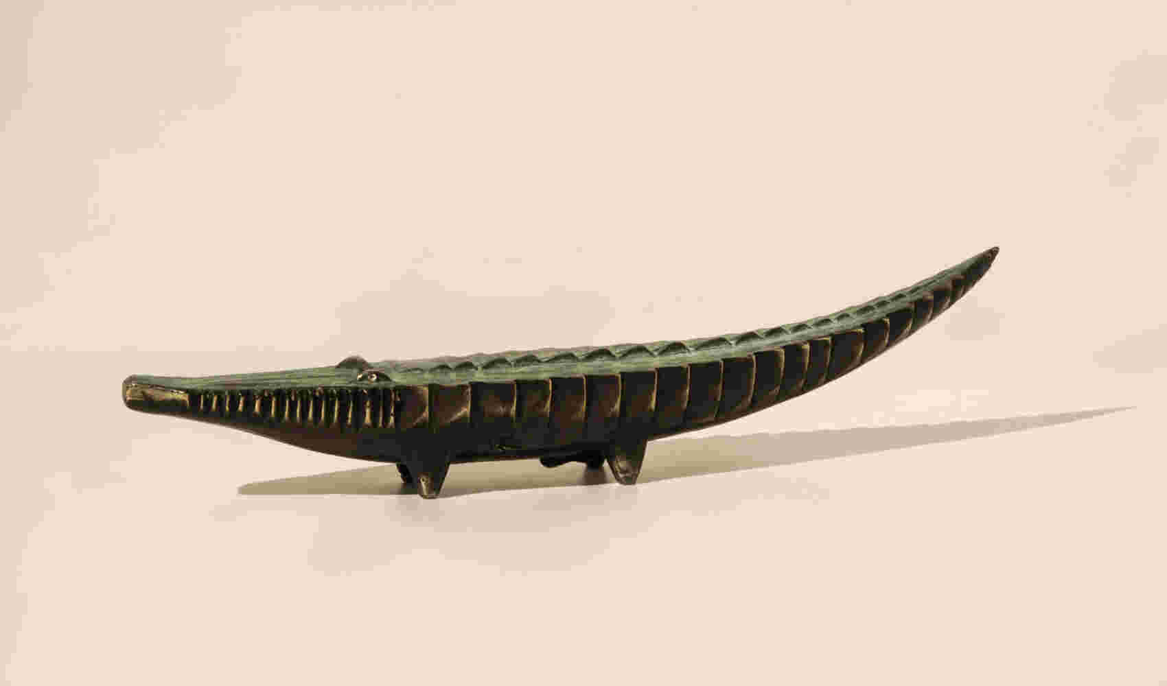 Small sculpture of a cast bronze crocodile finished with a green patina