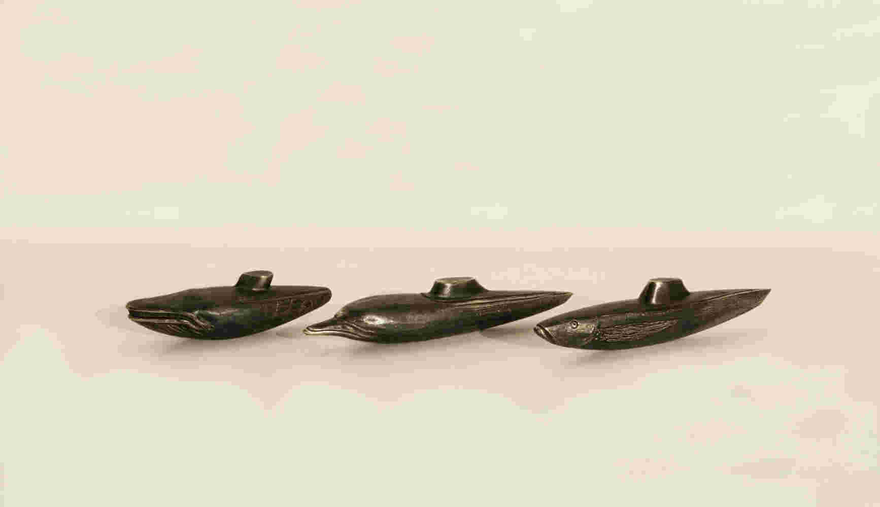 A small bronze sculpture of a hybrid between a dolphin and a submarine. 21x4x4cm