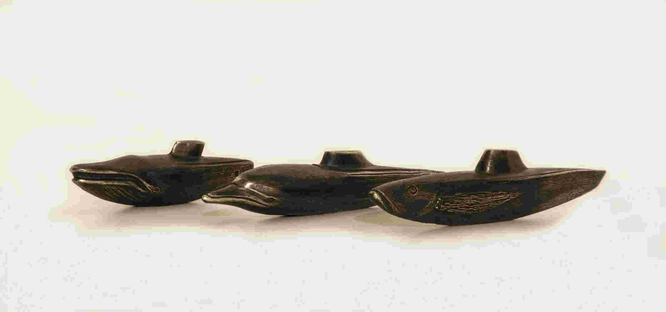 A small bronze sculpture of a hybrid between a dolphin and a submarine. 21x4x4cm