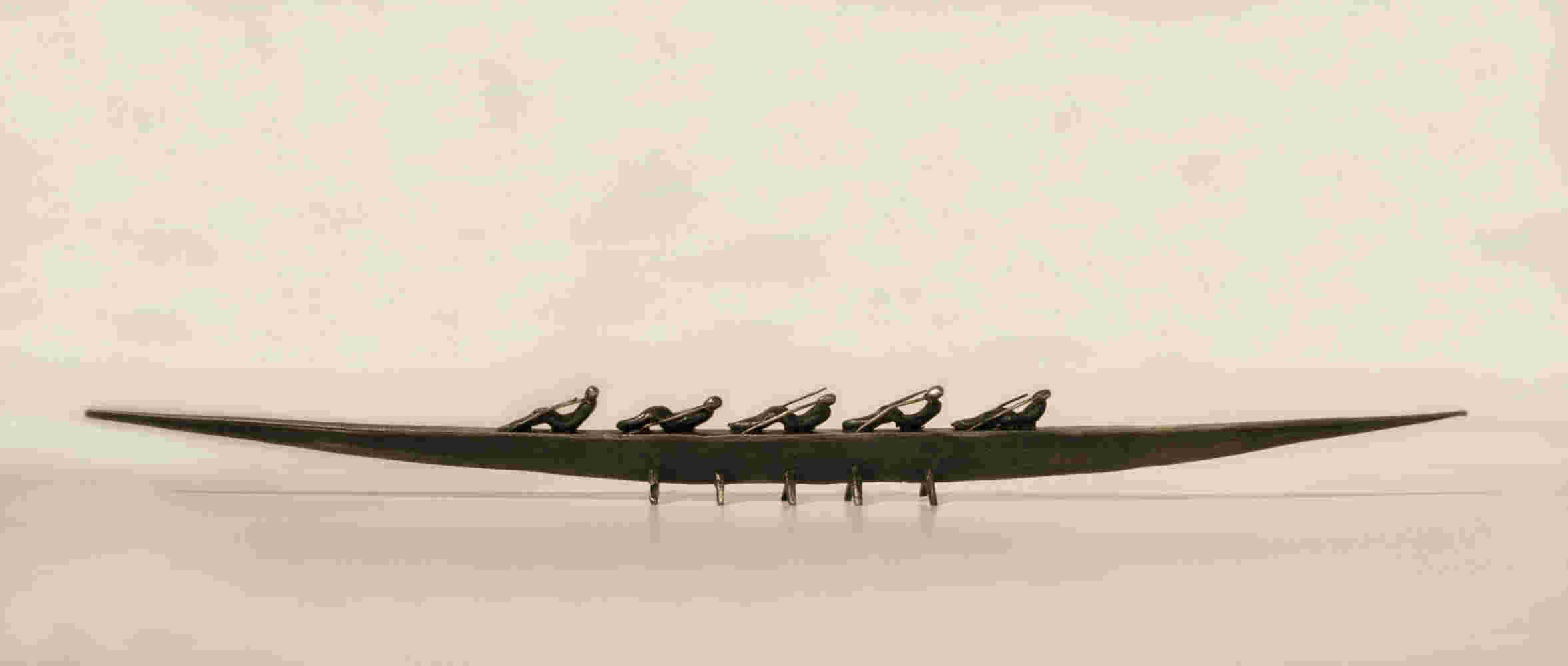 Small boat sculpture made of cast bronze.