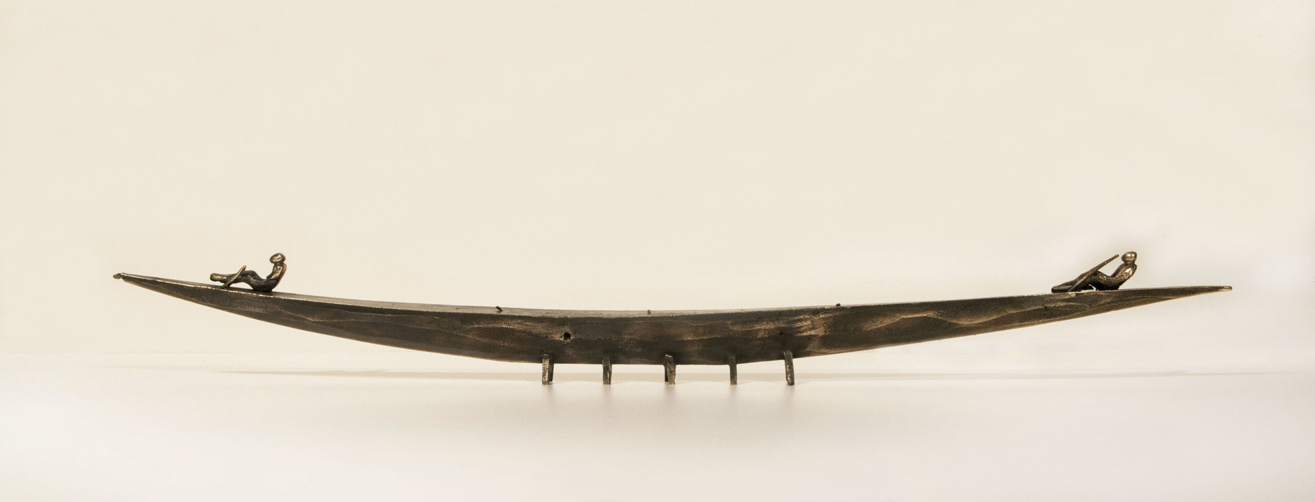 Small boat sculpture made of cast bronze.