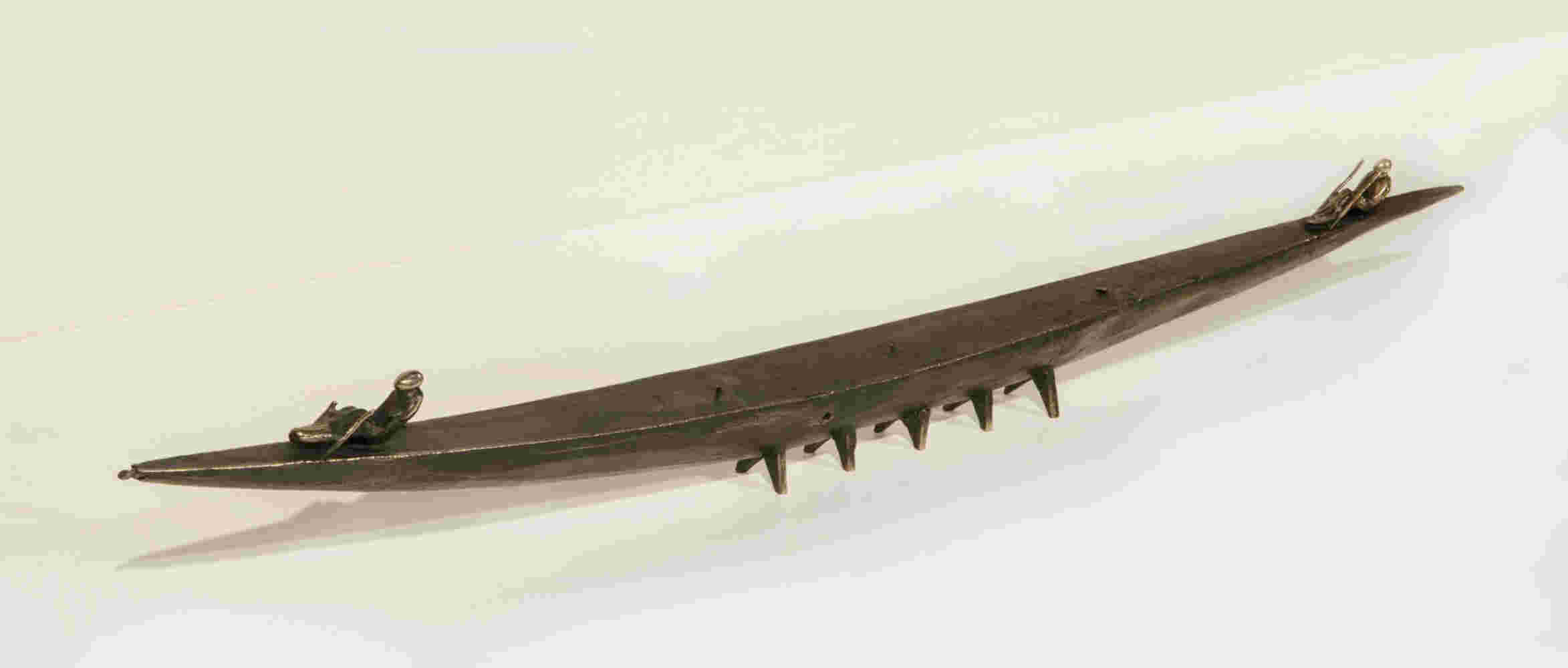 Small boat sculpture made of cast bronze.