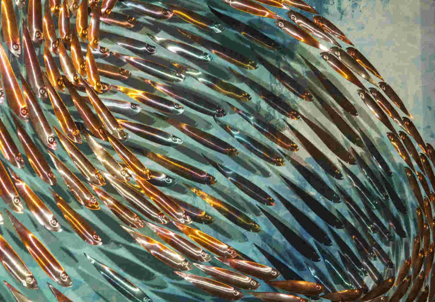 Three-dimensional wall sculpture, school of fish theme, with layers of plexiglass, aluminum frame and swirling copper fish.