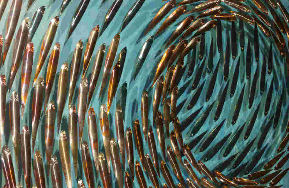 A 133 Three-dimensional wall sculpture, school of fish theme, with layers of plexiglass, aluminum frame and swirling copper fish.
