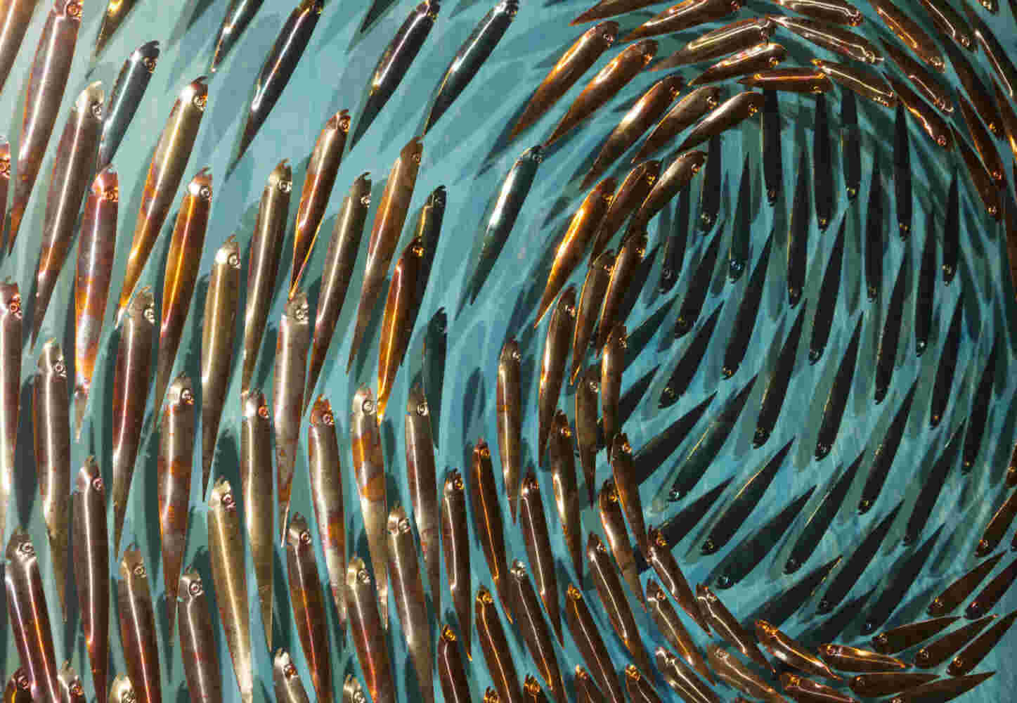 Three-dimensional wall sculpture, school of fish theme, with layers of plexiglass, aluminum frame and swirling copper fish.